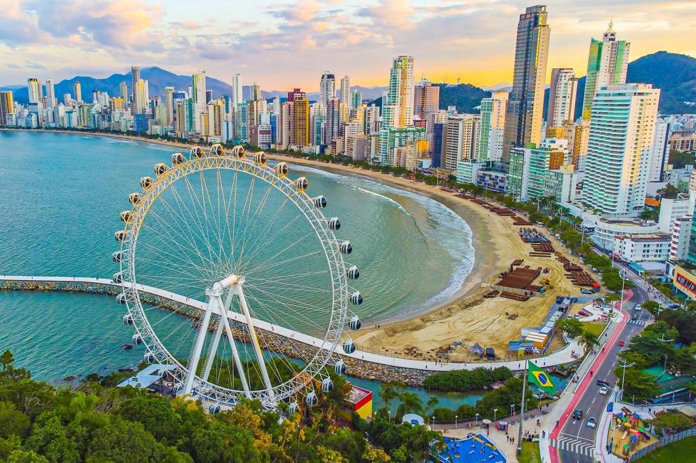 imagem aérea de balneário camboriu com vista para o mar, prédios e roda gigante